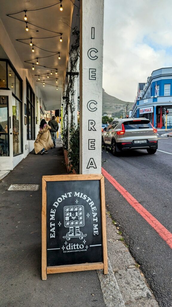 a black chalk board sign promoting ice cream options outside of ditto ice cream and waffles in cape town