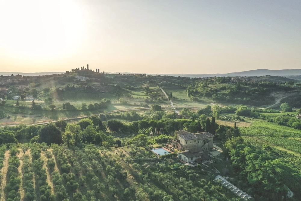 the tuscan countryside with a light mist over the hills at sunrise with the small vegan b and b I Pini Agrivilla in the foreground