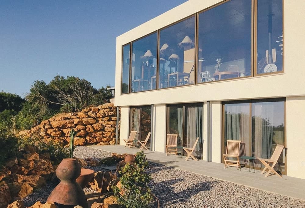 super modern eco lodge with natural stone and large windows in the dimming sun in portugal