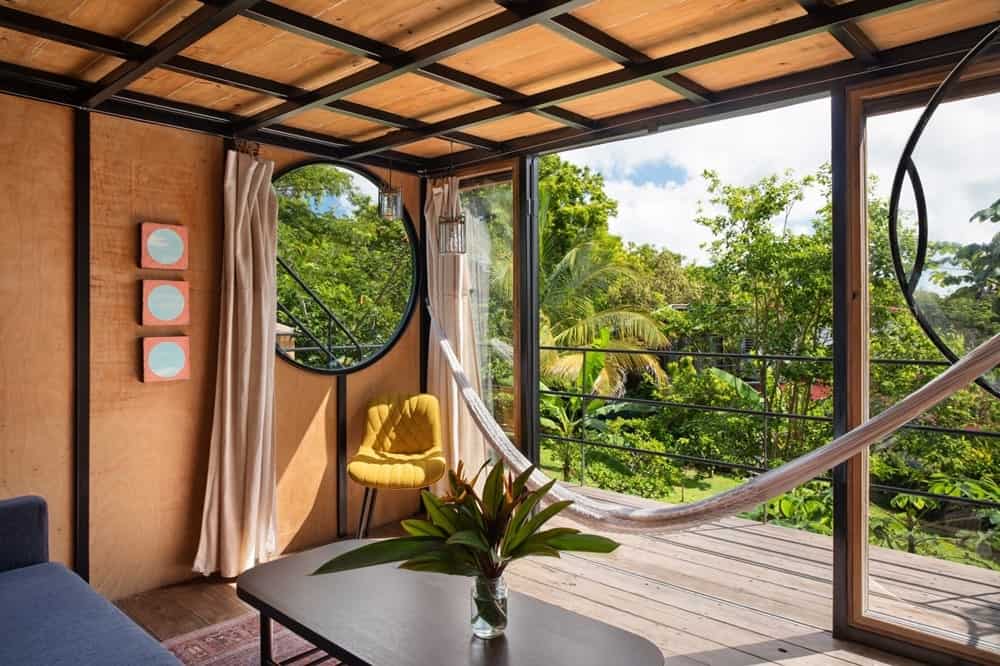 the outdoor patio attached to a treehouse room overlooking the lush jungle at the vegan hotel finca victoria in puerto rico