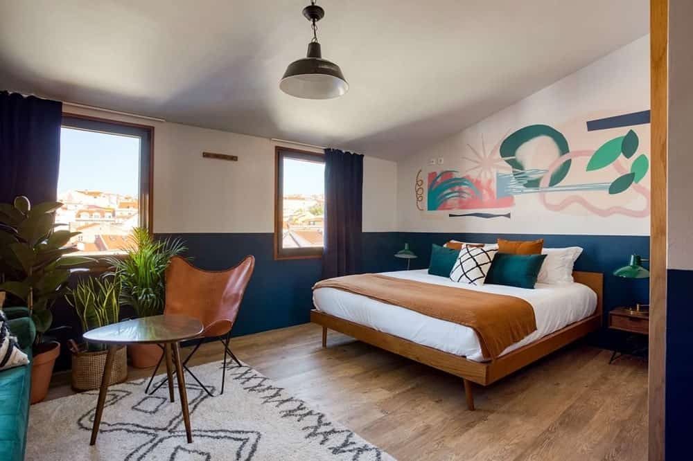 modern guestroom with wood floors and natural paint and bedding at a vegan-friendly hotel in lisbon