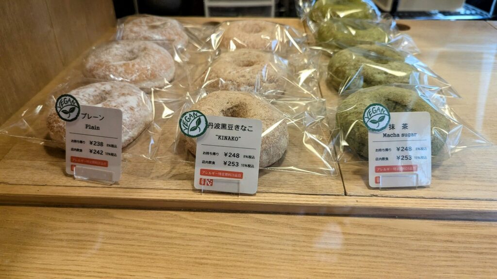 a tray of round vegan cake donuts in fun flavors like matcha at Doughnut Cafe Nicotto in kyoto