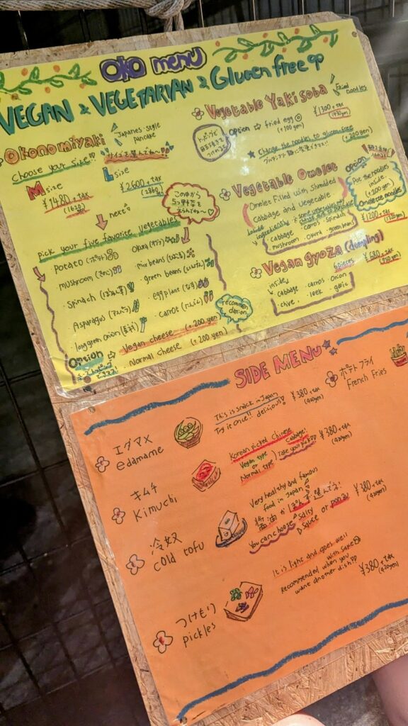 a bright yellow and orange hand written menu for OKO-Fun Okonomiyaki Bar 