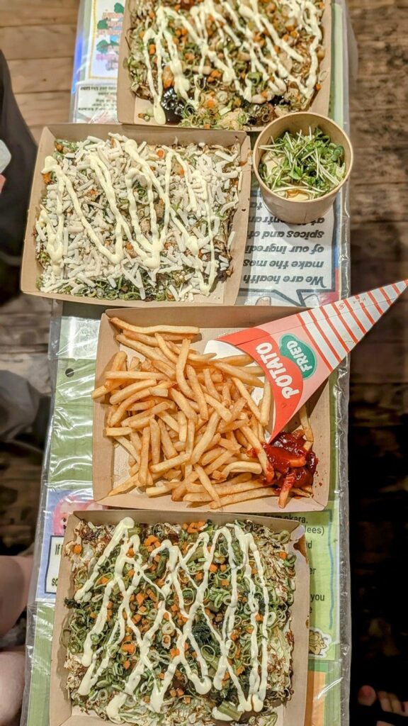 three orders of vegan okonomiyaki next to each other with an order of golden french fries at OKO-Fun Okonomiyaki Bar 