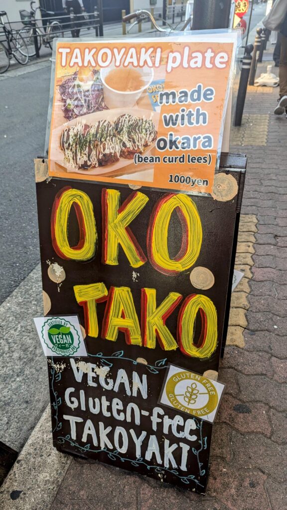 black chalk board sign with OKO TAKO written on it in front of the vegan spot OKO Takoyaki 