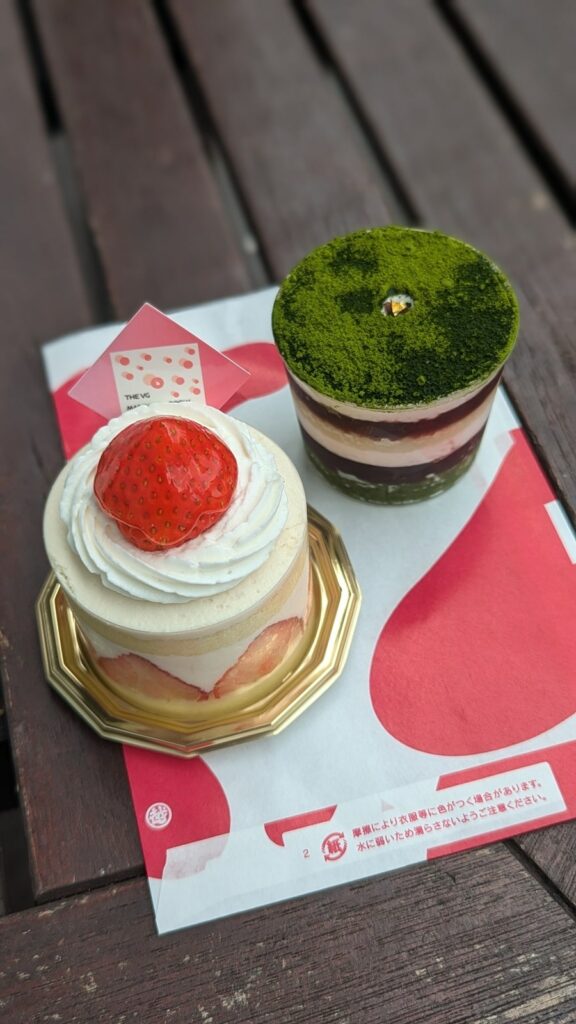 two mini vegan cakes one with layers of vanilla cake, slice strawberry, and cream and the other one topped with green matcha with layers of cream at The Vegan Marshmallooow