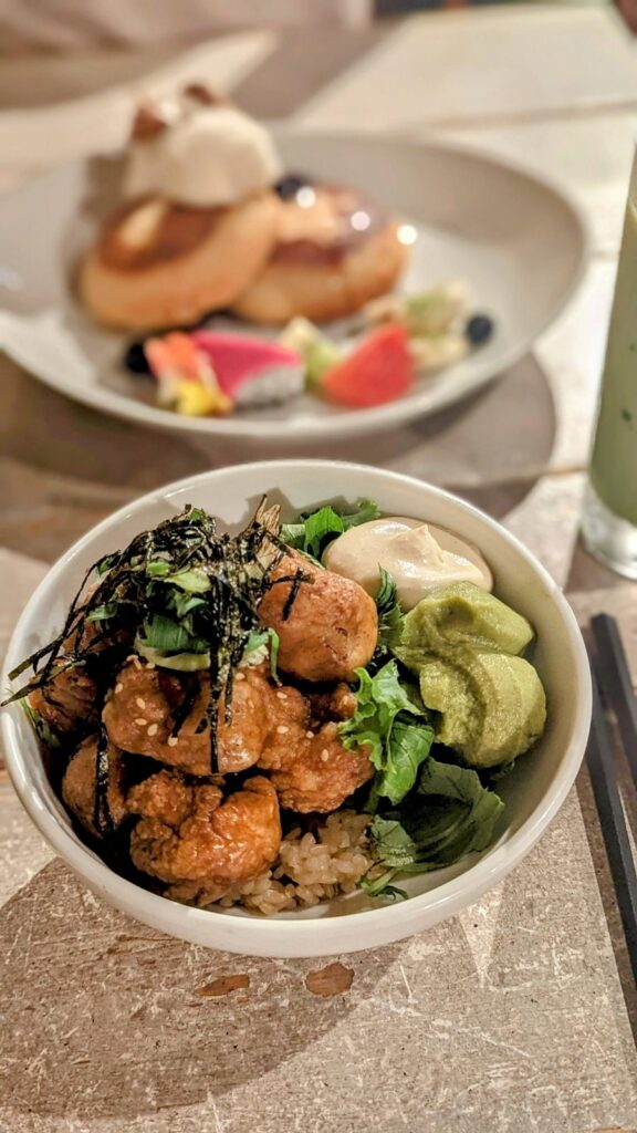 a small white bowl filled with green veggies and small chunks of golden fried vegan chicken at ain soph in kyoto