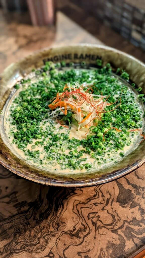 a large bowl of zesty ramen topped with green onions at engine ramen in kyoto