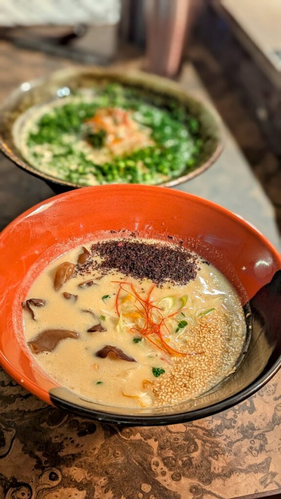 two bowls of creamy ramen, one up close with mushrooms and sesame seeds at engine ramen in kyoto