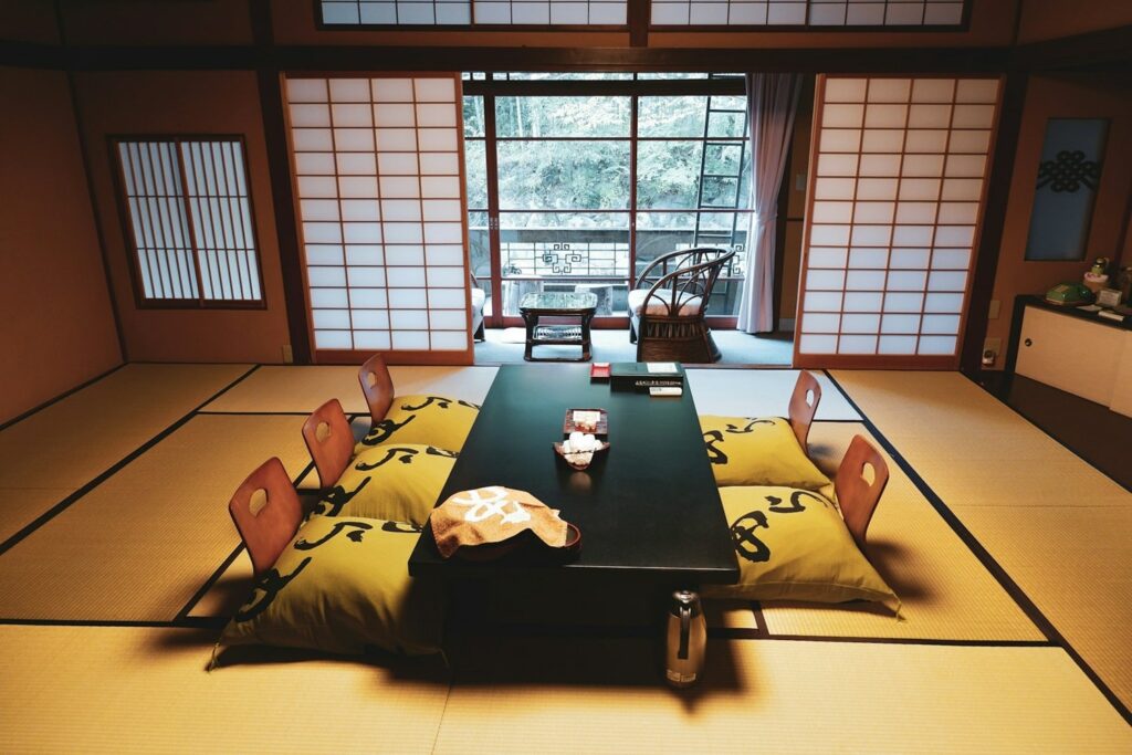 a traditional seating area with cushions on a tatami mat floor at a ryokan in japan