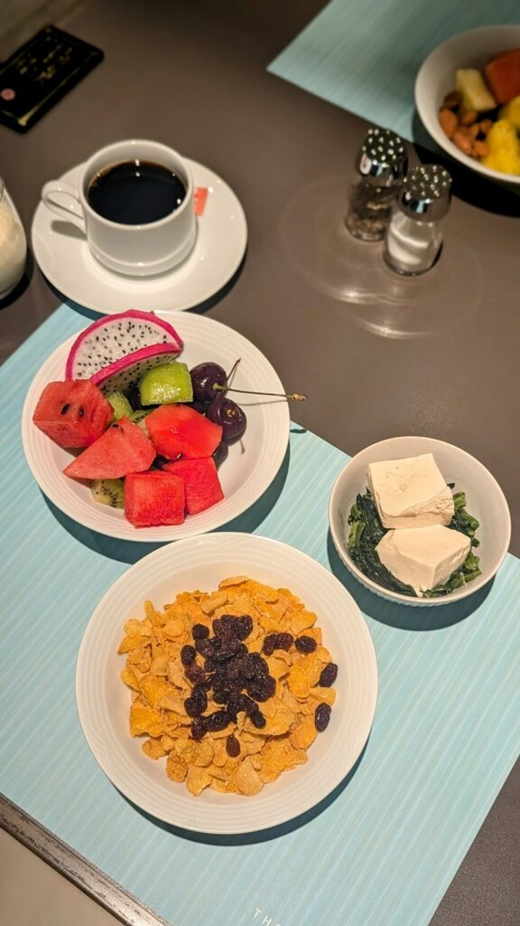 multiple vegan breakfast options - a bowl of corn flakes, fruit, tofu with spinach and coffee at the shiba park hotel in tokyo