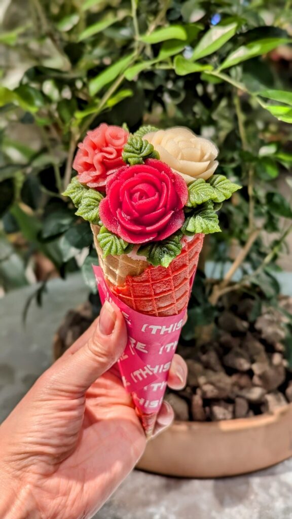 a vegan ice cream cone made to look like a pink and white flower bouquet in kyoto