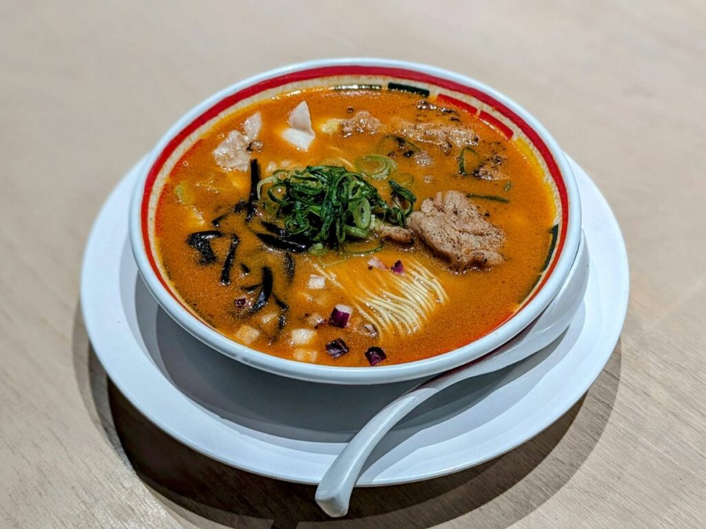 a large bowl of golden vegan ramen with a large amount of noodles and soy meat at vegan bistro jangara in tokyo