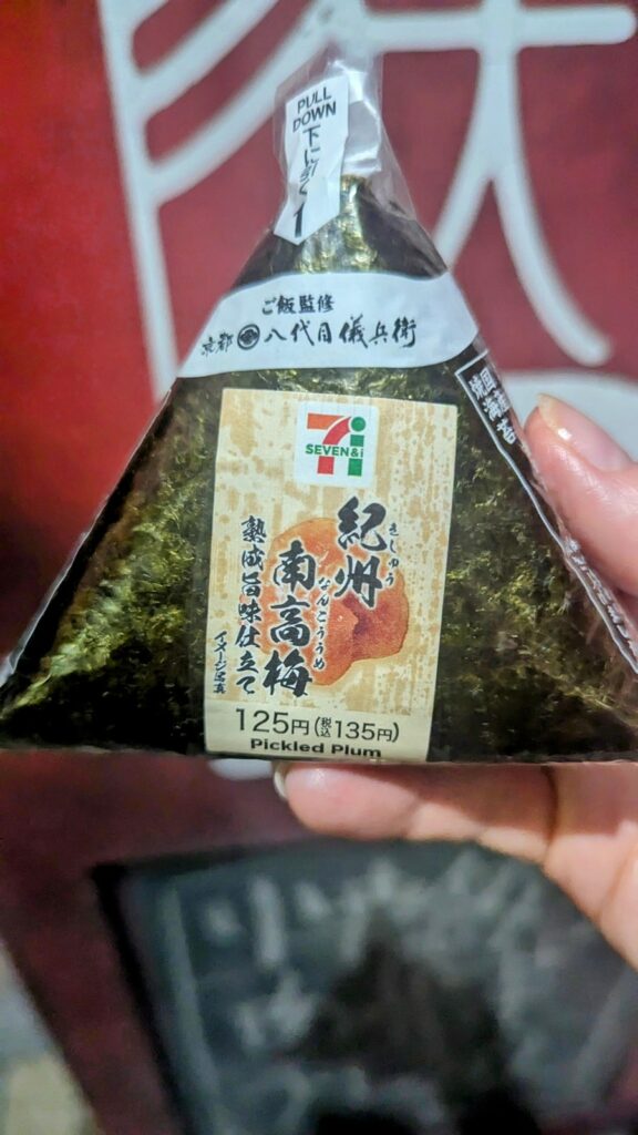 a vegan ogniri rice ball with pickled plum in wrapping from seven eleven in japan