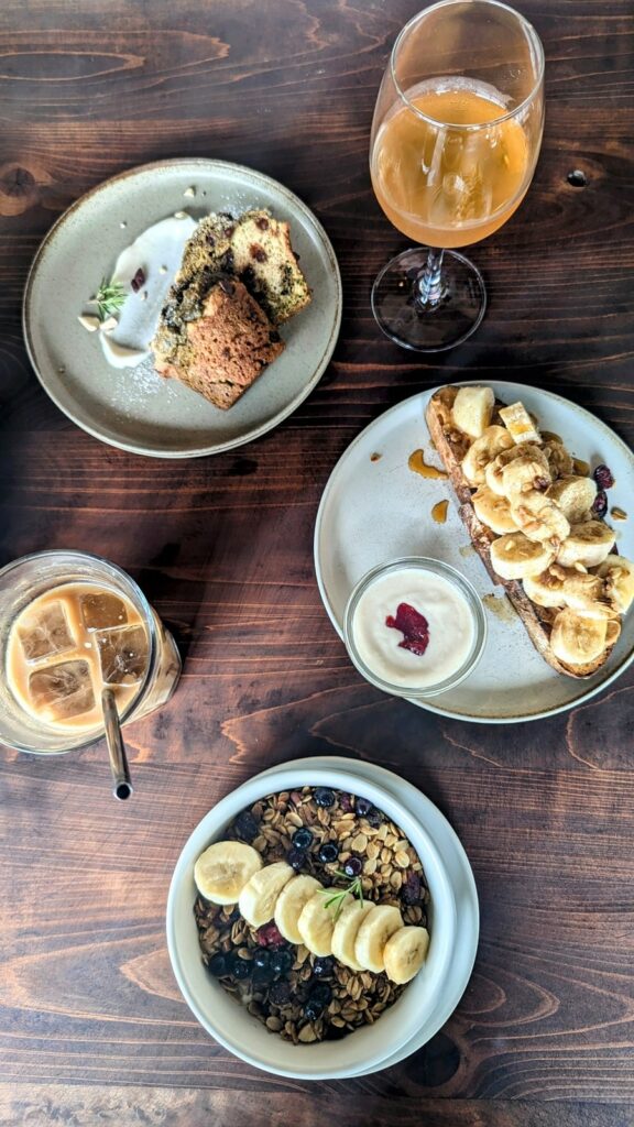 overhead view of vegan breakfast dishes like toast, a muffin, and granola on a wood table at veg out in kyoto