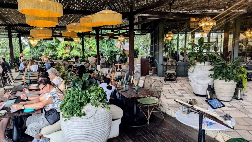 the boho chic dining room with wicker lighting and marble tables at plant bistro in ubud, bali