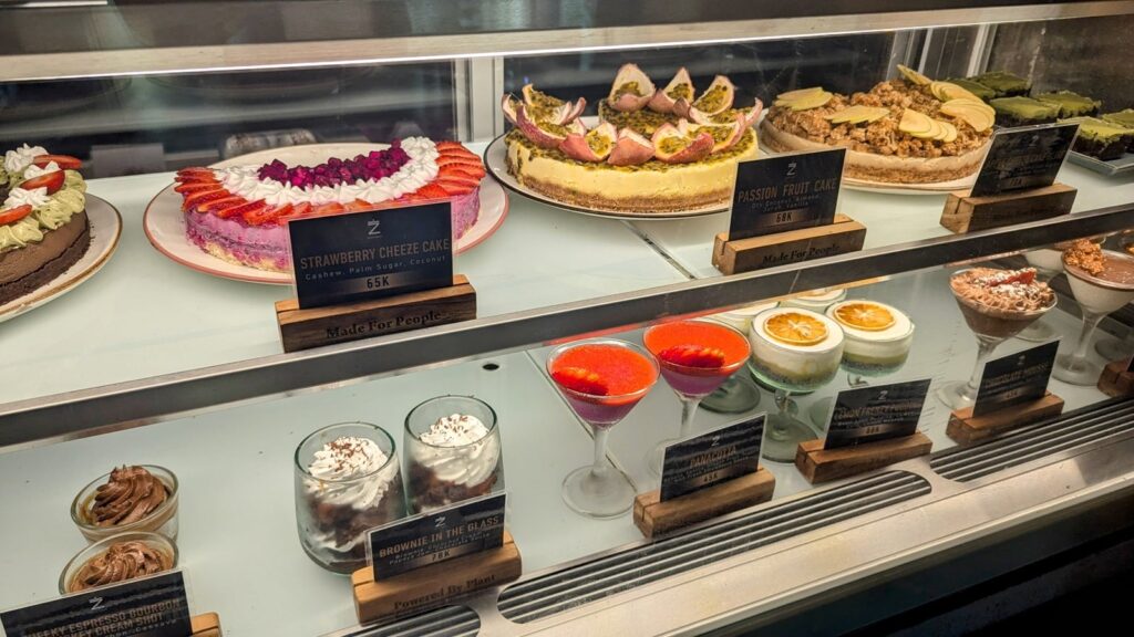 the large dessert case filled with large vegan cakes, cheesecakes and individual desserts and treats at zest in ubud, bali