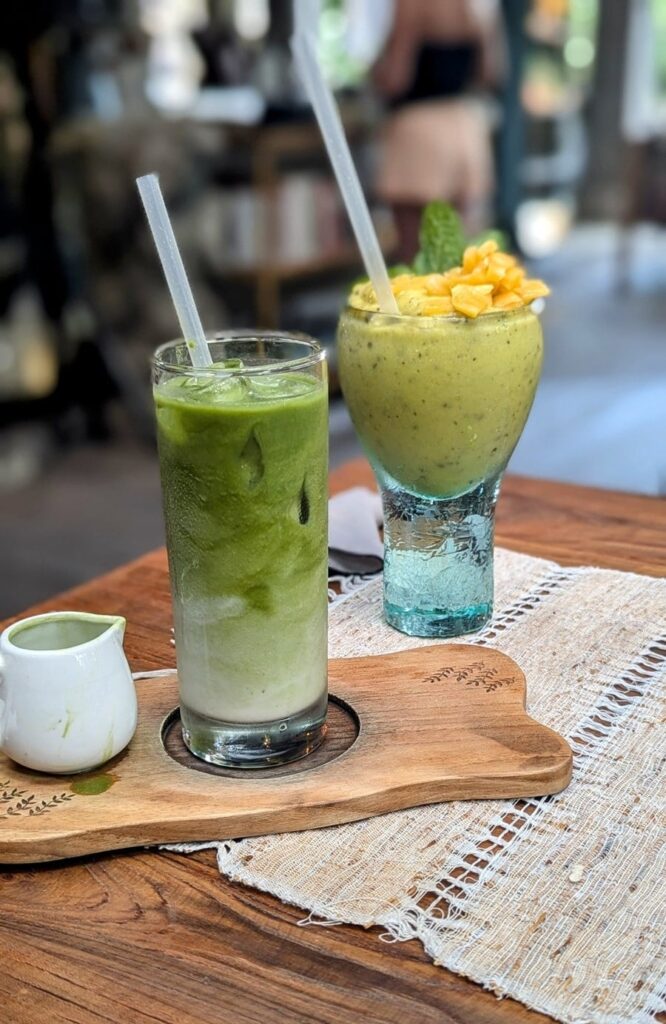 two colorful green drinks on a wood serving platter at zest ubud