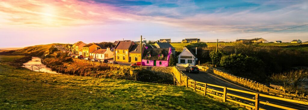 a quaint little village with colorful homes in the middle of the green countryside of ireland