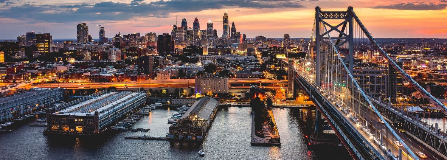 overhead shot of philadelphia at nighttime with the city dimly lit and the sun almost set