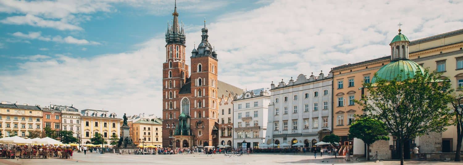 old town square with very few people on a partly cloudy day in krakow, poland