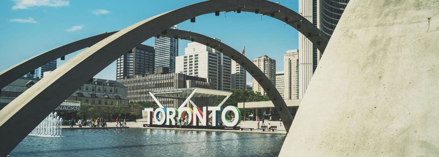 the giant toronto city sign in the middle of the city on a sunny day