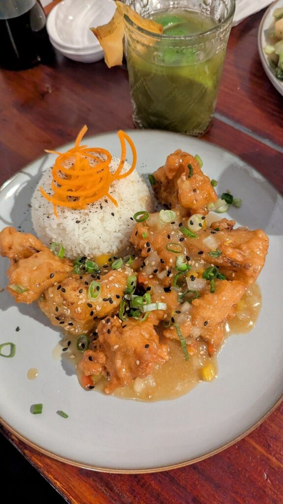 golden tempura fried vegan cauliflower covered in a sweet sauce with a pile of rice at Terrestre-Cocina-Compasion in san juan