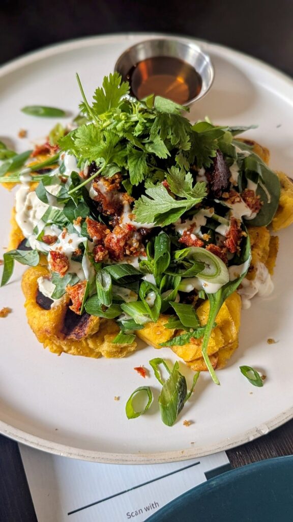 vegan plantain waffle topped with seitan bacon bits, greens, and cashew cream at el grifo in cayguas