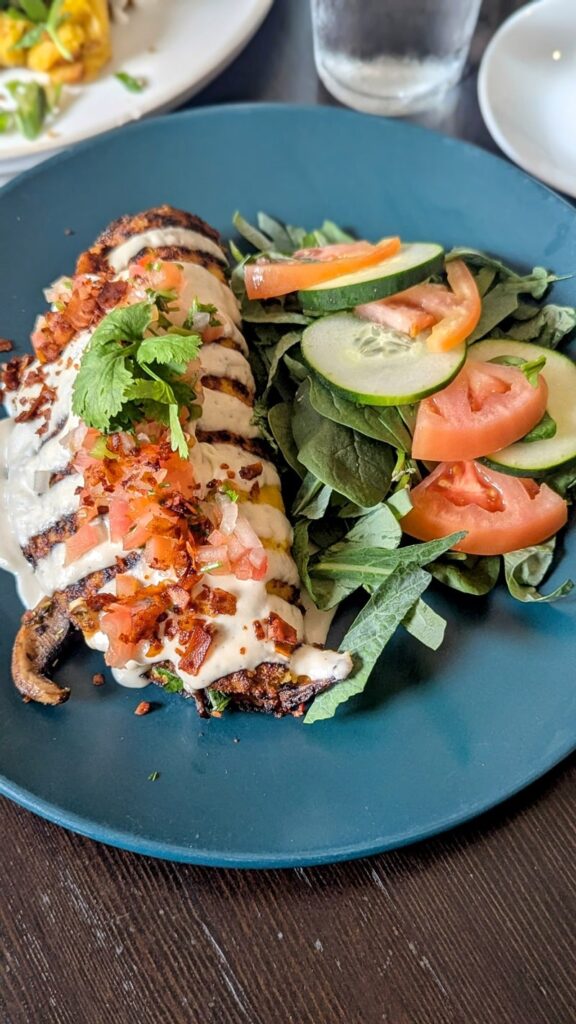 vegan puerto rican tortilla with garbanzo beans, greens and cashew cream next to a simple salad at el grifo in cayguas