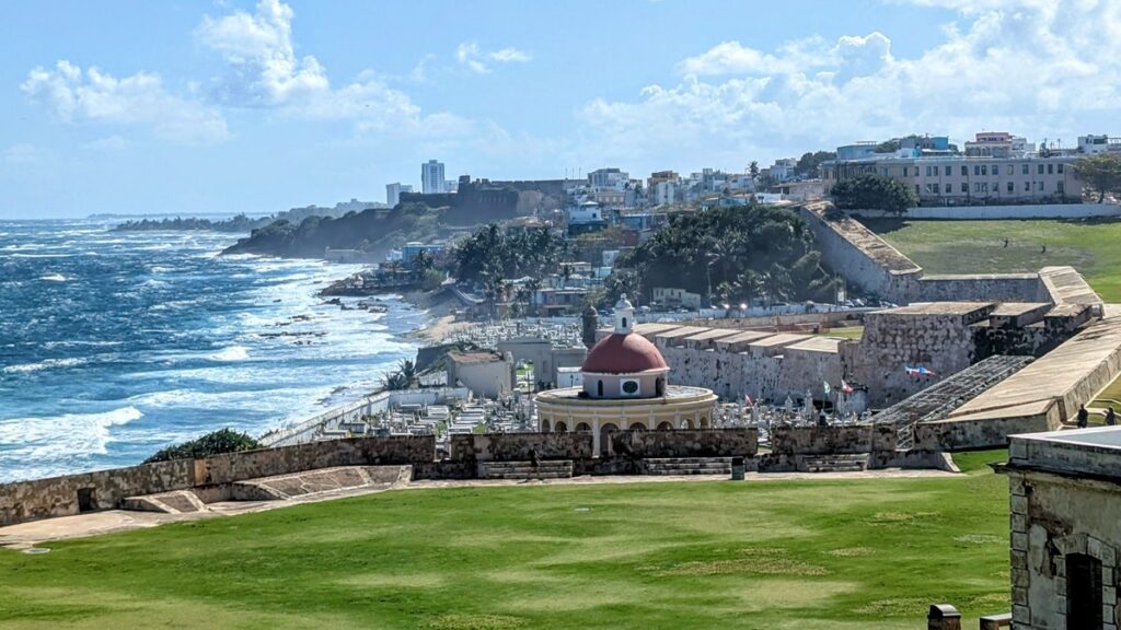 coastline around old san juan on a partly cloudy day with the la perla community in the background surrounded by an old military fort wall