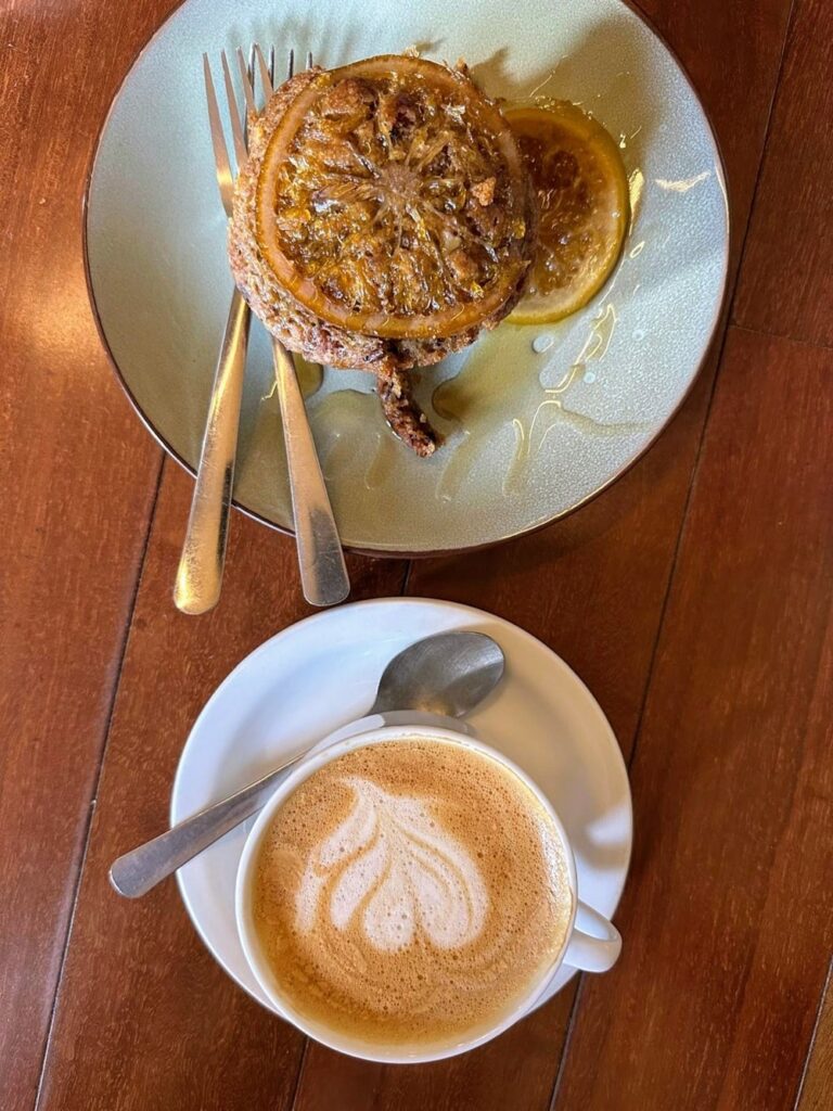 vegan latte next to a small slice of cake at cafe rojo in san jose