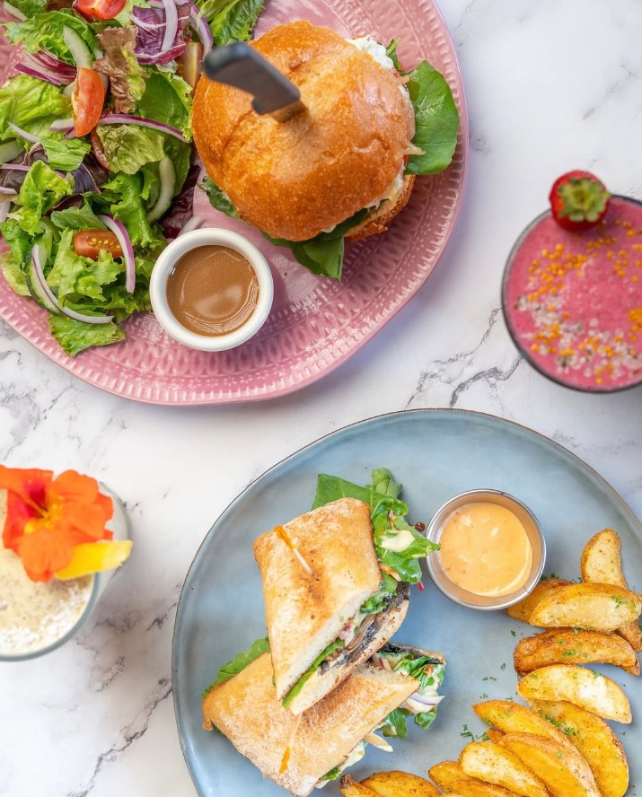 overhead shot of a vegan burger and a sandwich on a marble table at el buho in san jose costa rica