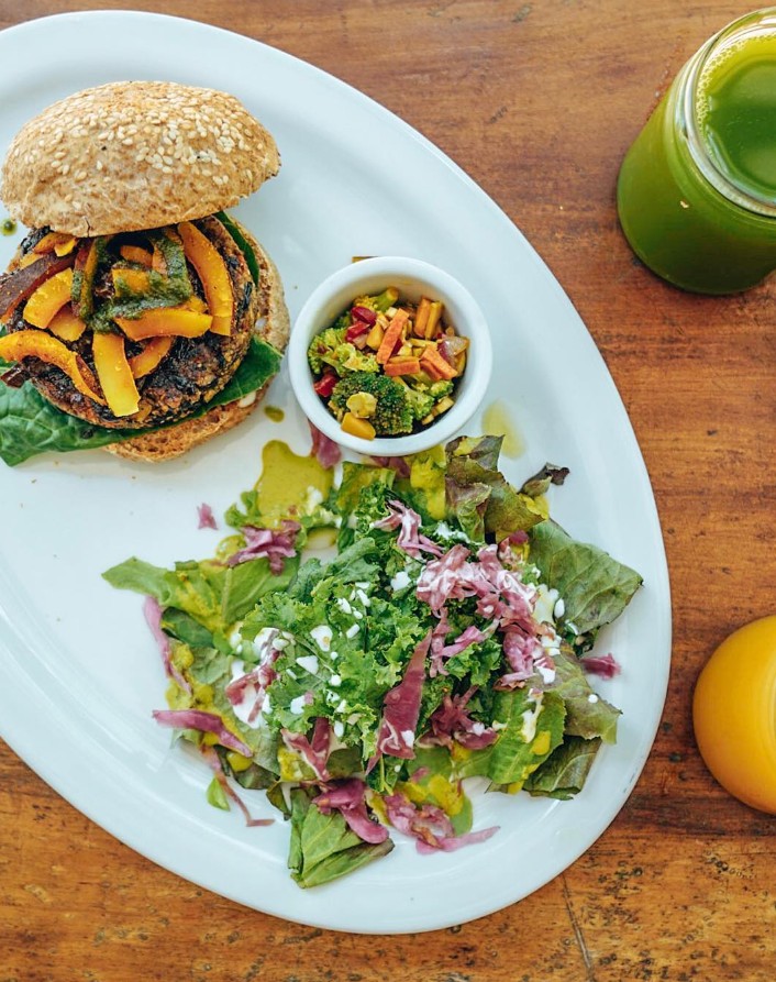 vegan black bean quinoa burger with a small salad and a green juice at naked foods in nosara