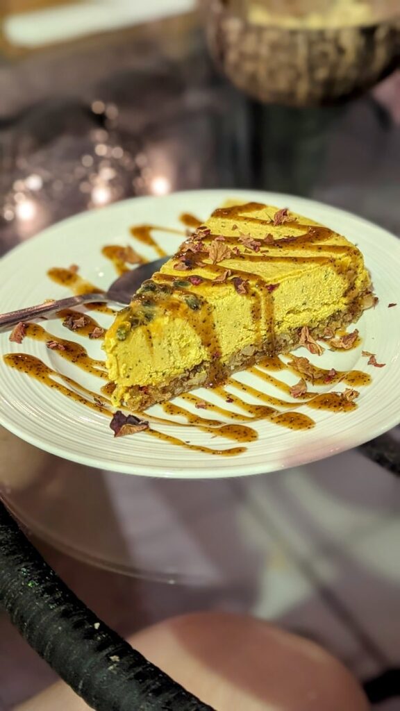 a small slice of vegan cake that's yellow and drizzled with a chocolate sauce at varuna plant based in manuel antonio in costa rica