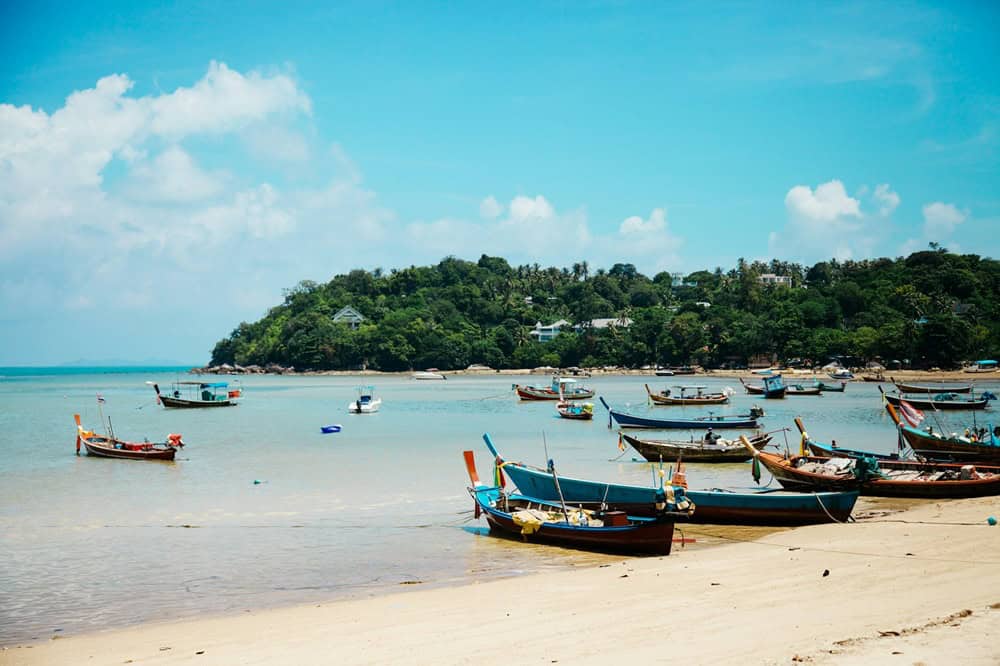 turquoise waters and white sand surrounding the island of koh samui in thailand