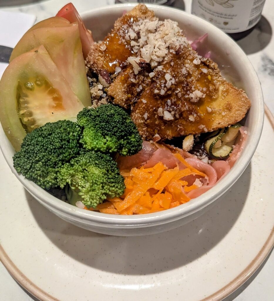 a colorful vegan bowl with fried tofu, tomato, broccoli and carrots at vegan and veggie in medellin