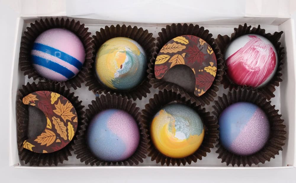 a box of eight colorful handmade vegan chocolates all in a row from Nutriente Pastry Studio in las vegas