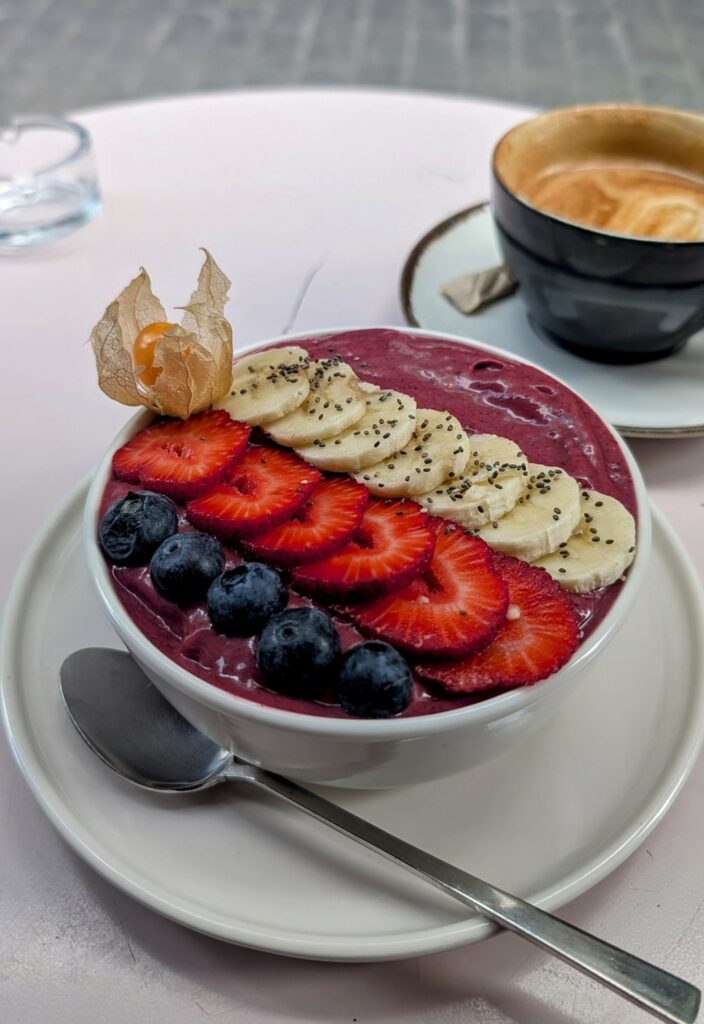 a purple acai bowl topped with sliced banana, strawberries and blueberries at Dükkan Galata in istanbul