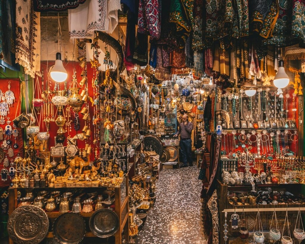 a vendor with rugs and antiques in the dimly lit grand bazaar in istanbul