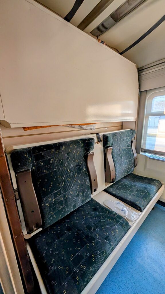 a shared cabin without the beds made on, with two single seats an overnight train in turkey