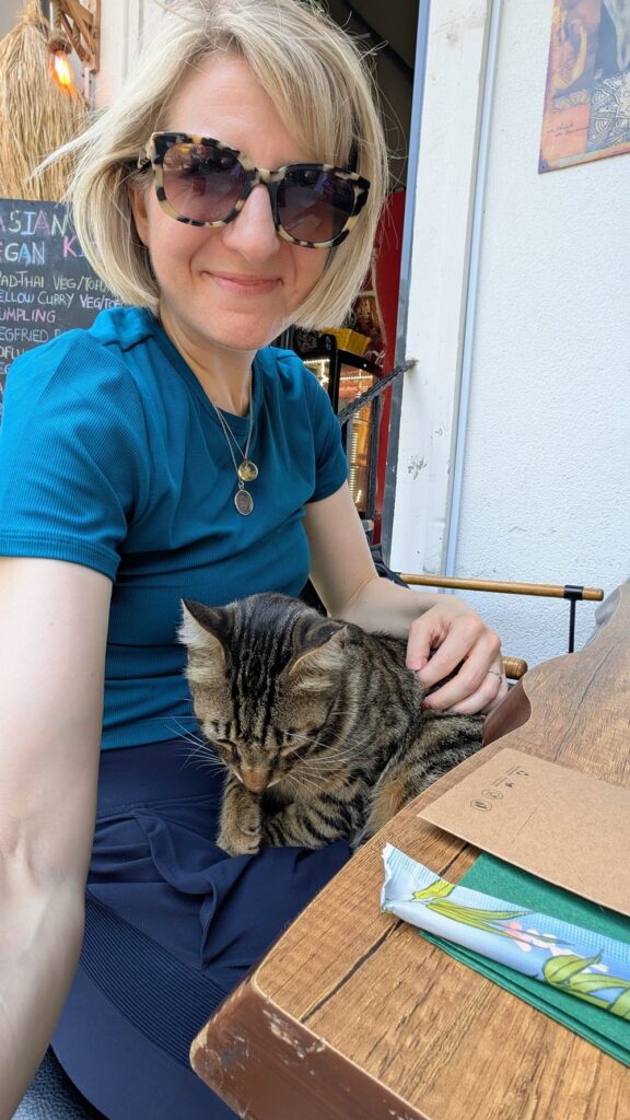 a black and tan tabby cat sitting on the lap of rebecca gade at Asian Vegan Kitchen in istanbul