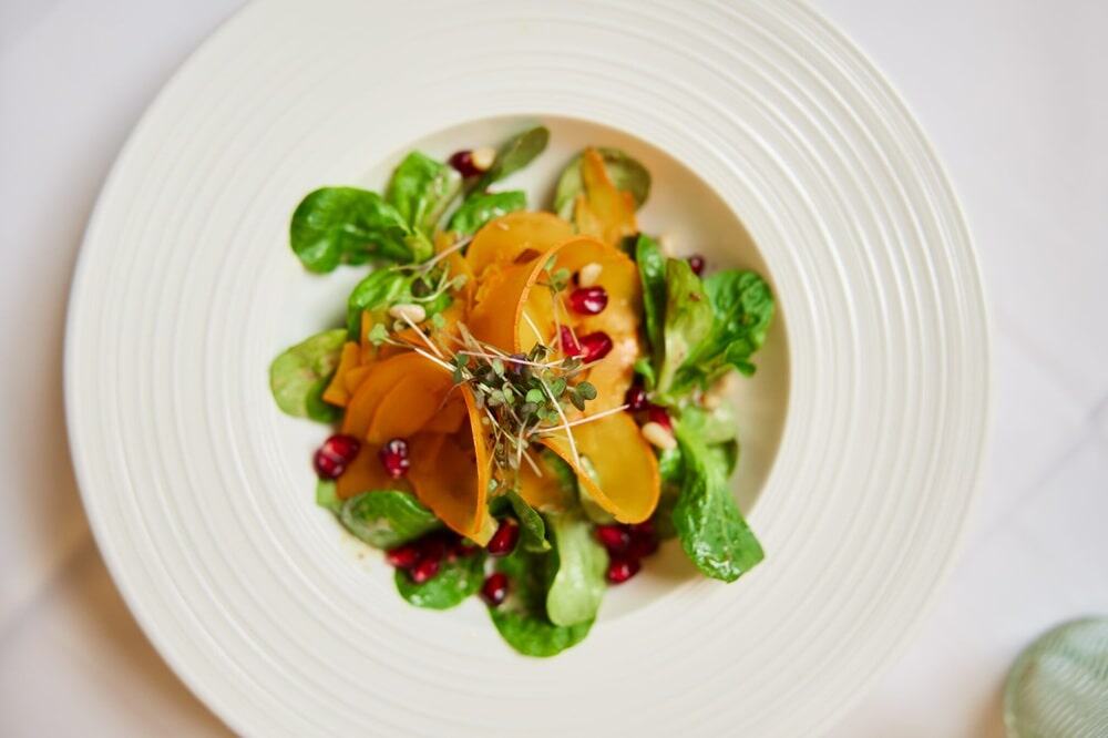 overhead shot of a colorful veggie dish in a white bowl at aheadburg hotel in germany