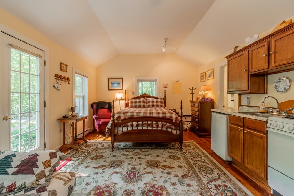 a cozy queen bed with handmade quilts in a large dimly lit guestroom at the vegan b and b the white pig inn