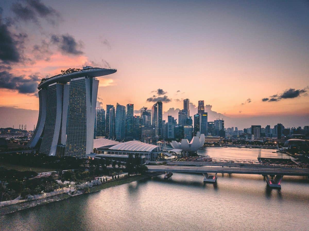 famous marina in singapore as the sun is setting with a pink and orange sky