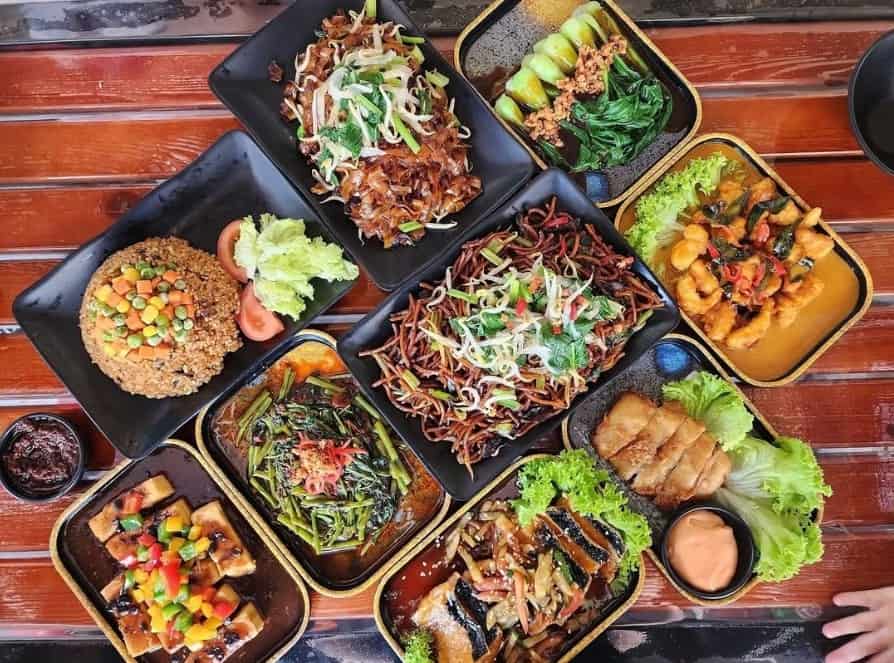 a table filled with multiple vegan dishes from makan vegan in sigapore