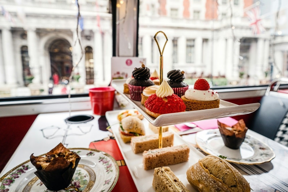 tiered trays filled with vegan cakes, desserts and sandwiches for vegan high tea in london