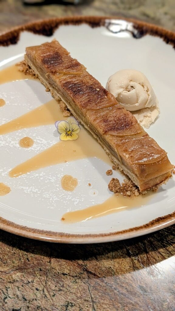 a skinny slice of vegan apple pie with a caramel drizzle on a white plate at Jardineiro in porto