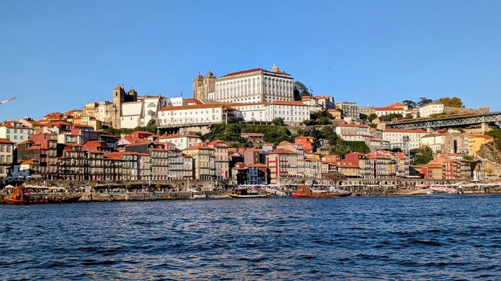 one of porto's many hills filled with colorful buildings along the river front at dusk