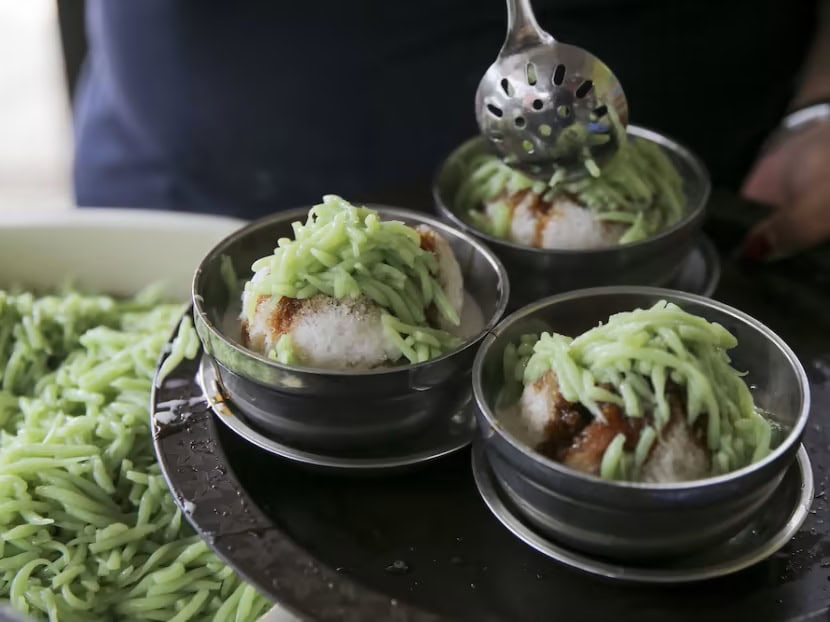 two bowls of vegan chendol. the bowls are filled with green noodles, shaved coconut and shaved ice in singapore