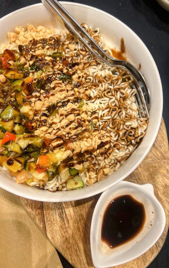 a bowl of vegan ramen topped with a sark soy sauce, chopped veggie and peanuts at fangas veg in coimbra